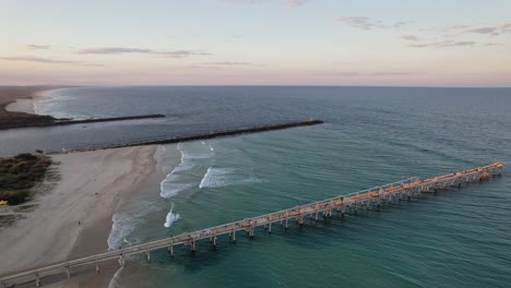Aerial-View-Of-Sand-Pumping-Jetty-At-The-Spit-On-The-Gold-Coast-In-Queensland,-Australia-At-Sunset---drone-shot