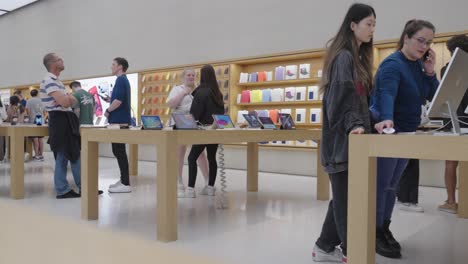 Belebter-Apple-Store-In-Glasgow-Mit-Mitarbeitern-Und-Kunden,-Die-über-Produkte-Diskutieren