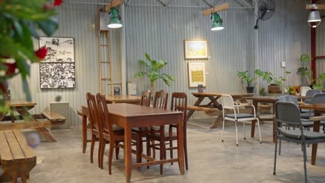 Eine-Ecke-Des-Schönen-Cafés-Mit-Vielen-Klassischen-Tischen-Und-Stühlen,-An-Deren-Wand-Architekturzeichnungen-Hängen