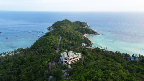 Aerial-view-of-hotel-resort-in-Koh-Tao-Island-with-green-hills,-beach-and-clear-ocean-water-in-Thailand