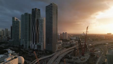 Aerial-Futuristic-Skyscrapers-in-Downtown-Miami-with-Construction-Development-During-Sunset