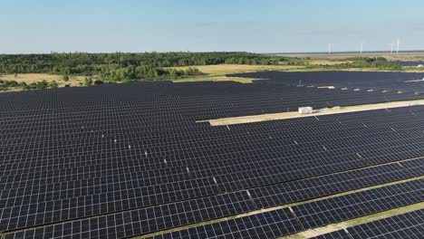 Grüne,-Nachhaltige-Energieerzeugung-In-Einer-Photovoltaik-Solarpanel-Plantage-Mit-Windturbinen-Luftaufnahme