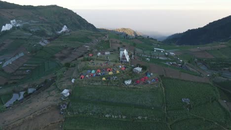 Aerial-view-over-Skoter-Hill-with-the-campsite-near-Dieng-Kulon-village,-Batur-district-in-Central-Java