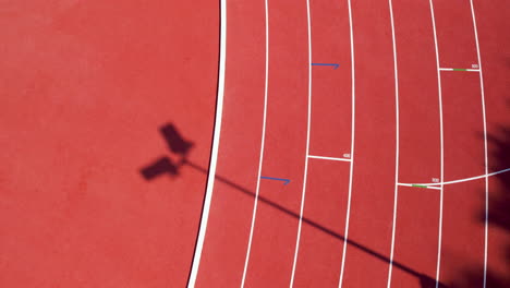 Top-down-aerial-view-of-a-lamppost's-shadow-cast-on-the-track-at-an-athletics-stadium