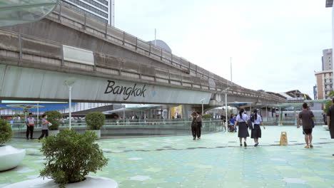 BTS-Skytrain-with-Traffic-sky-walk-area-connects-Siam-Discovery-department-store-and-MBK-Center-over-the-Pathumwan-Intersection-in-evening,-Bangkok-Thailand