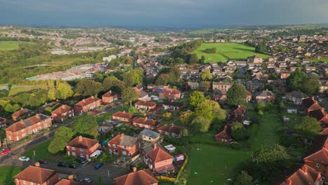 UK-housing-scene:-Aerial-view-of-Yorkshire's-red-brick-council-estate-on-a-sunny-morning,-with-residents-adding-life-to-the-lively-streets