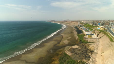Aerial-view-overlooking-the-Playa-Chorillos-beach,-sunny-day-in-Huacho,-Peru