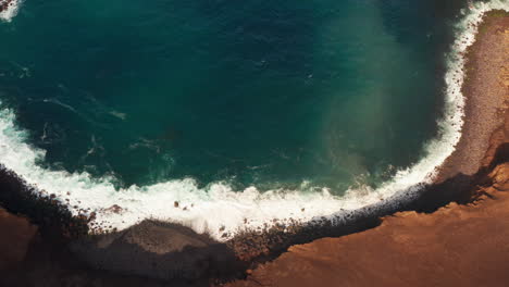 Top-Down-aerial-drone-shot-of-Capelinhos-volcano-coastline-in-Faial-Island,-Azores---Portugal-Wavy-turquoise-ocean-crushing-against-the-volcanic-cliffs