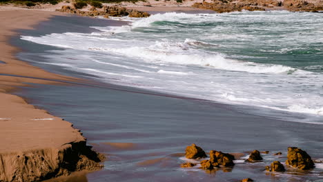 Timelapse-of-waves-crashing-onto-pristine-secluded-sandy-beach,-shore-break