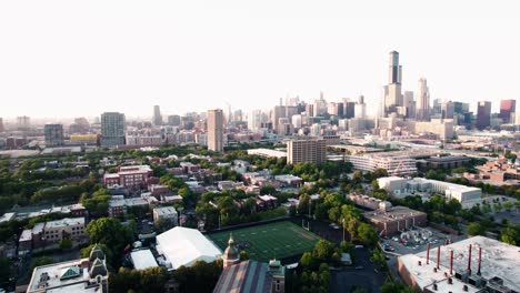 chicago-view-aerial-from-suburbs,-large-american-footbal-stadium-field-on-right-also-known-as-gridiron-football