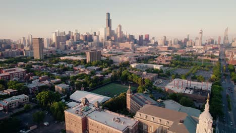 orbiting-chicago-aerial-revealing-large-american-footbal-stadium-field-and-a-church