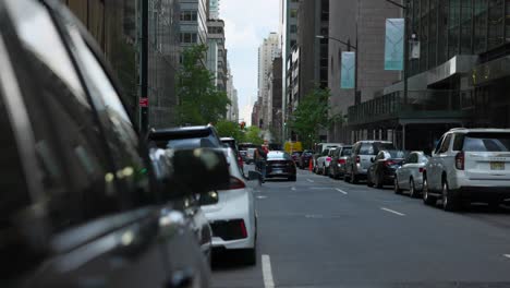 Slow-motion-wide-shot-of-busy-streets-of-New-York-City,-USA-with-cars-parked-during-overcast-day