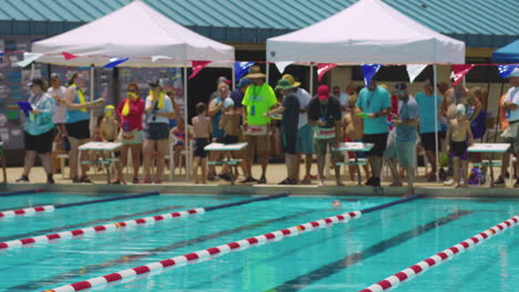 People-Stand-On-The-Edge-Of-Swimming-Pool-During-Competition