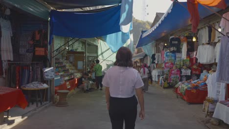 Rear-view-of-Woman-walking-along-Street-market-in-Chiang-Mai,-Slow-motion-shot