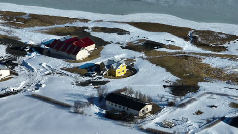 Aerial-telephoto-shot-of-a-detached-house-and-farm,-sunny-winter-day-in-Iceland