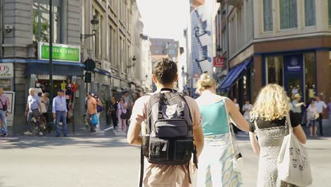 Tourist-walking-in-the-city-center-streets-of-Brussels,-crossing-the-road-at-the-TinTin-wall