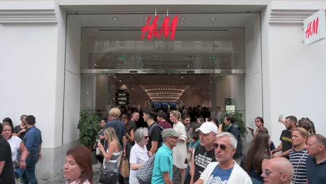 Se-Ven-Compradores-Y-Peatones-Frente-A-La-Multinacional-Sueca-De-Diseño-De-Ropa,-La-Empresa-Minorista-Hennes-Y-Mauritz,-Tienda-H-Y-M-En-España