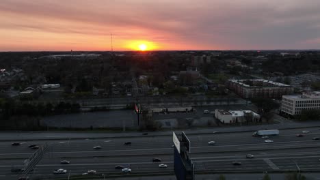 Aerial-view-of-Downtown-Connector-free-flowing-traffic-at-sunset,-Ralph-David-Abernathy-Freeway,-Interchange,-Camera-pans-right-to-reveal-famous-skyline-buildings-and-landmarks-in-the-background