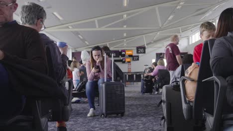 Passengers-keep-themselves-entertained-while-waiting-for-flight-to-be-announced
