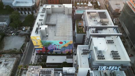 Aerial-of-air-district-Wynwood-at-sunset-with-skyscraper-building-painted