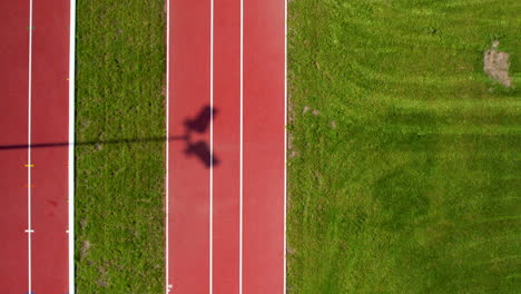 Luftaufnahme-Der-Laufstrecke-Zwischen-Der-Rasenfläche-Im-Stadion-An-Einem-Sonnigen-Tag-Von-Oben-Nach-Unten---Überführung