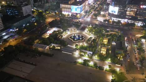 Night-time-aerial-of-Wulin-Square,-a-bustling-urban-square-located-in-the-Xiacheng-District-of-Hangzhou,-China