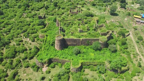 Aerial-drone-shot-of-an-Ancient-fort-or-castle-abandoned-and-covered-with-thick-green-forest-in-Gwalior-Madhya-Pradesh-India