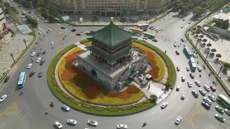Aerial-orbiting-shot-of-commuters-driving-around-the-Xian-Bell-Towe-in-China