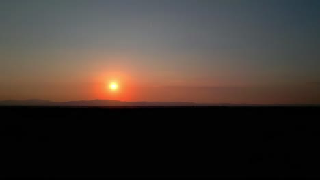 Sun-setting-in-the-horizon-beyond-the-mountains---Timelapse