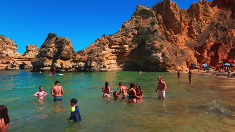 Menschen,-Die-Den-Strand-Betreten,-Um-Die-Sonne-Zu-Genießen,-Praia-Do-Camilo-An-Der-Algarve,-Lagos,-Portugal