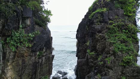 Cinematic-aerial-flyover-of-tall-coastal-rocks-revealing-breathtaking-ocean-reef-waves-in-Baras,-Catanduanes