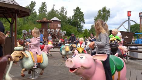 Kids-and-adults-having-fun-on-spinning-family-carousel-inside-Djurs-theme-park-in-Denmark