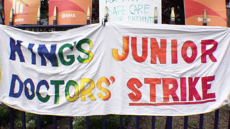 Auf-Einem-Bunten-Banner,-Das-An-Einem-Geländer-Befestigt-Ist,-Steht:-„Kings-Junior-Doctors&#39;-Strike“-Weht-Im-Wind-Auf-Einer-Streikpostenlinie-Streikender-Berater-Und-Assistenzärzte