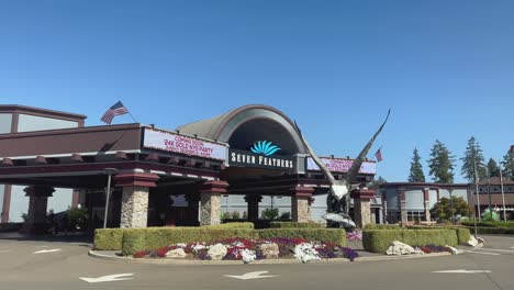 People-walk-into-the-Seven-Feathers-Casino-underneath-an-American-flag-and-eagle-statue