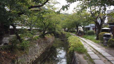 Hand-Held-Shot-of-Tourists-Walking-at-Philosopher's-Path,-Green-Landscape-Kyoto-Japan-in-Summer