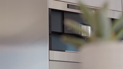 Slow-orbiting-shot-of-a-drinks-dispenser-integrated-into-a-refrigerator-in-a-kitchen