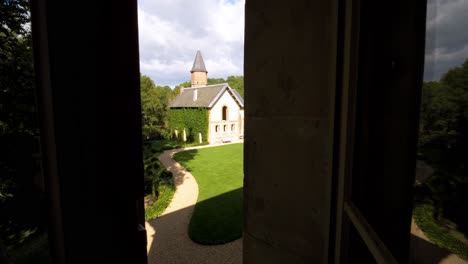 Peering-through-the-window,-the-view-unfolds-onto-a-scene-of-timeless-beauty,-showcasing-the-rich-tapestry-of-France's-traditionally-built-architectural-heritage