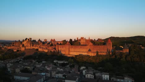 Toma-Aérea-En-Ascenso-De-La-Hermosa-Ciudadela-Medieval-De-Carcassonne-En-Francia-Durante-La-Hora-Dorada.