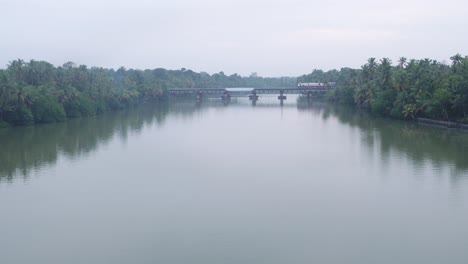 Indischer-Eisenbahnzug-Fährt-Sehr-Langsam-Auf-Einer-Brücke-über-Den-Fluss-In-Kerala