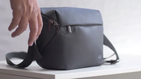 The-DJI-drone-bag-is-resting-on-the-table-and-is-picked-up-by-male-hands