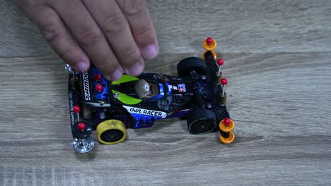 A-balck-racer-with-the-Tamiya-logo-dropped-many-times-to-test,-Tamiya-Mini-4X4