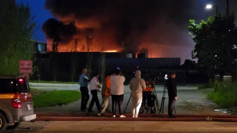 Camarógrafos-Filmando-Un-Edificio-En-Llamas-Por-La-Noche---Entrevistando-A-Un-Oficial-De-Policía-Durante-El-Incendio