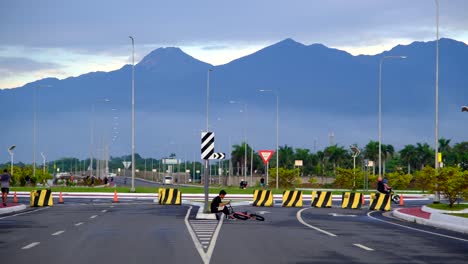 A-Road-junction-with-road-signs,-traffic-lights,-and-a-mountain-in-the-background