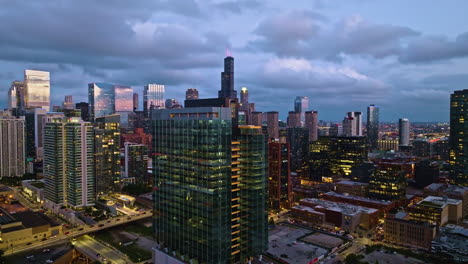 Drone-shot-approaching-the-360-North-Green-skyscraper,-sunrise-in-Chicago,-USA