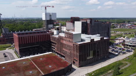 Vuelo-Aéreo-Hacia-Atrás-Desde-Edificios-En-Be-mine-Beringen,-Bélgica