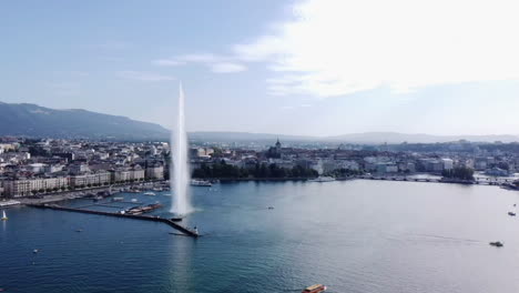 Aerial-circling-the-Jet-d'Eau-fountain-in-Geneva-on-sunny-day,-Switzerland