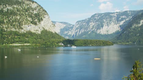 Hallstätter-See-Mit-Fahrenden-Booten-Und-Berghintergrund-An-Einem-Sommertag