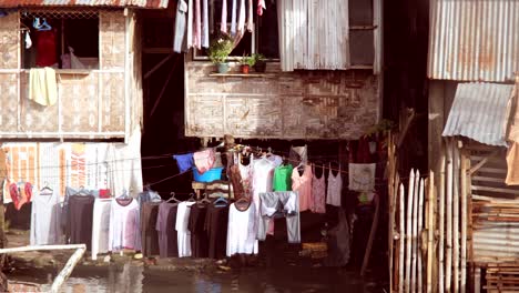 A-floating-home-made-of-low-cost-materials-living-on-the-water-with-clothes-hanging-by-the-side-of-the-houses