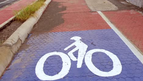 A-bicycle-marking-sign-on-the-pathway-with-unrecognizable-people-in-the-background