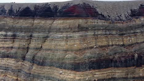 Pan-across-sedimentary-rock-strata-on-steep-wall-in-volcano-crater